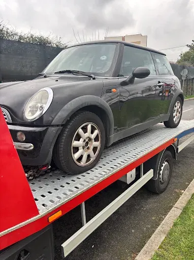 Mini Cooper noire chargée sur le plateau de la dépanneuse
