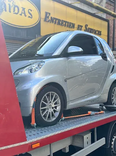 Smart accidentée déposée sur plateau devant un garage Midas partenaire